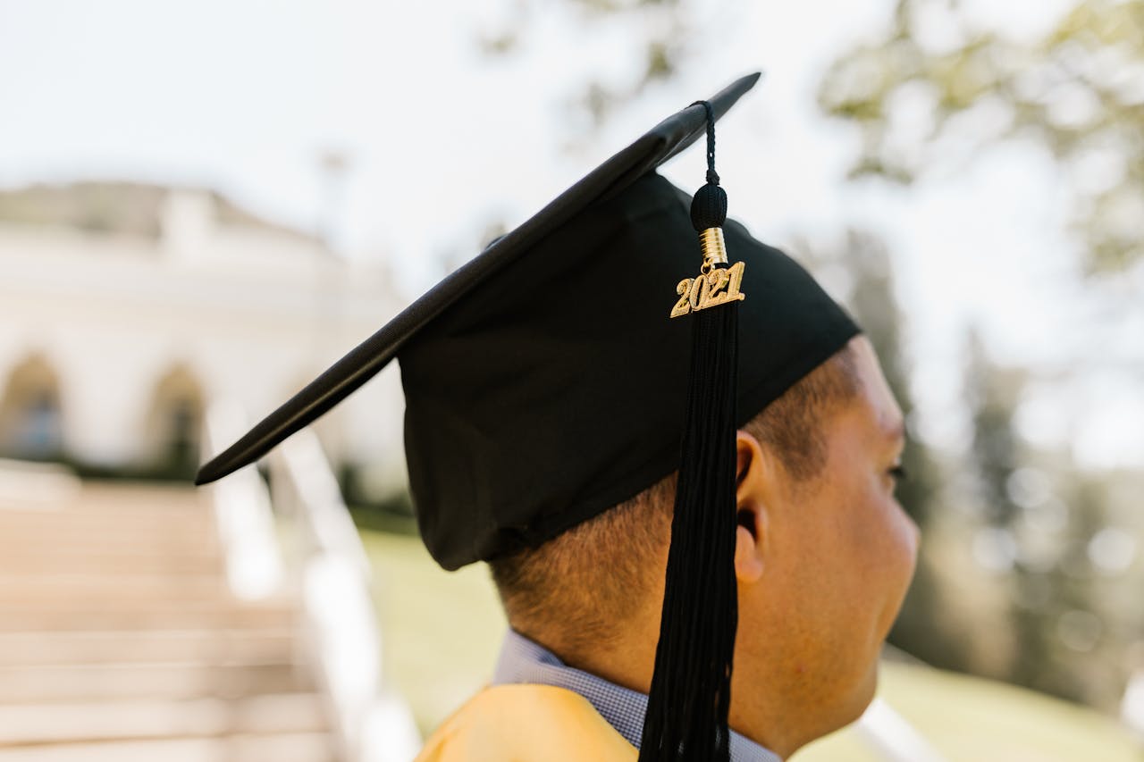 Graduate wearing mortarboard celebrates achievement on sunny day