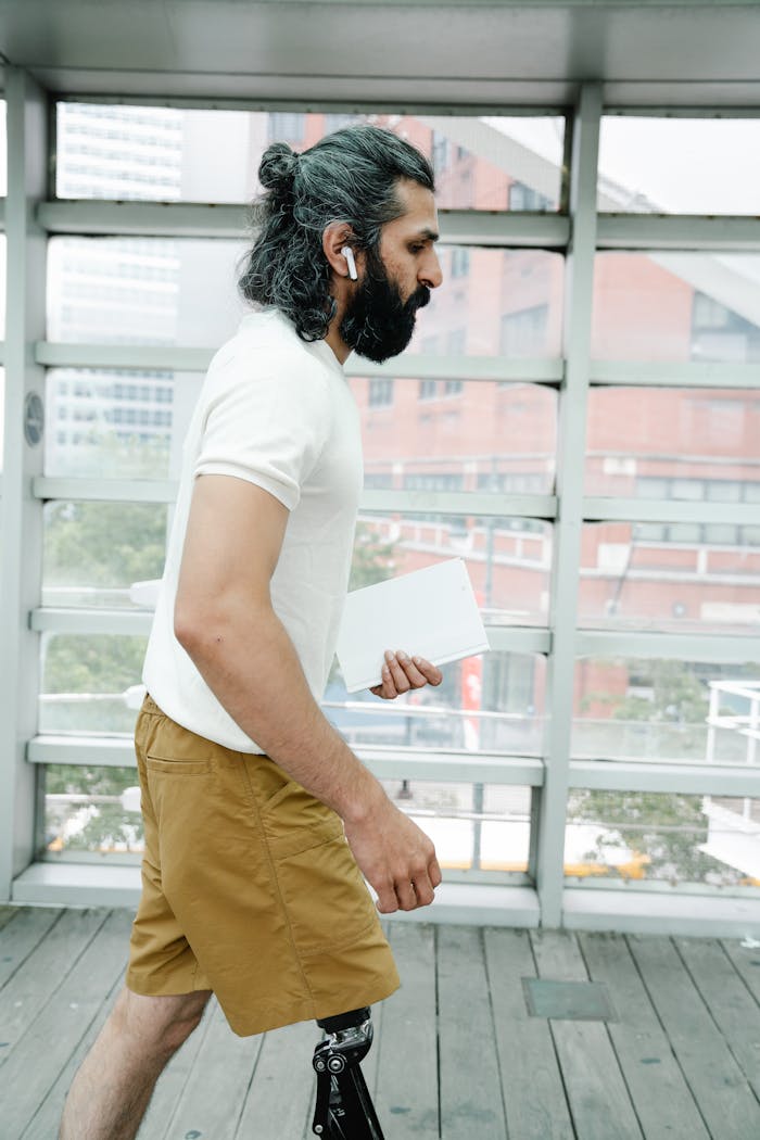 Side view of a man with a prosthetic leg walking indoors with confidence.